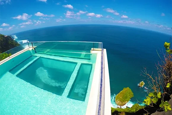 Close-up of the famous glass-bottom infinity pool at Oneeighty Bali, cantilevered over a 500-foot cliff.