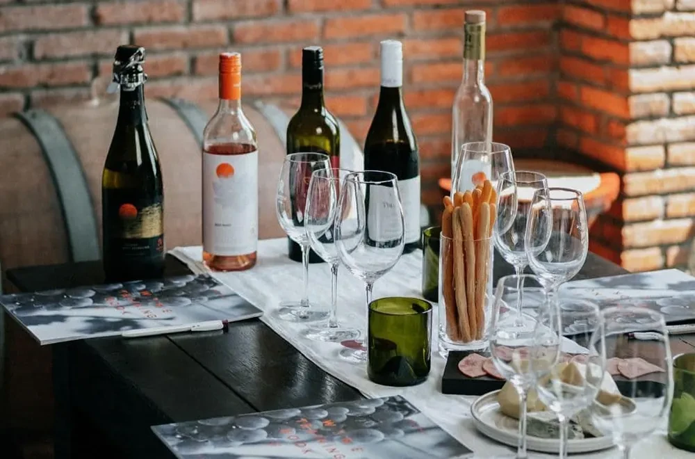 Guests enjoying a communal wine-tasting lunch at Hatten Wines Cellar Door in Bali, featuring rustic brick interiors and premium Bali-grown wine pairings.