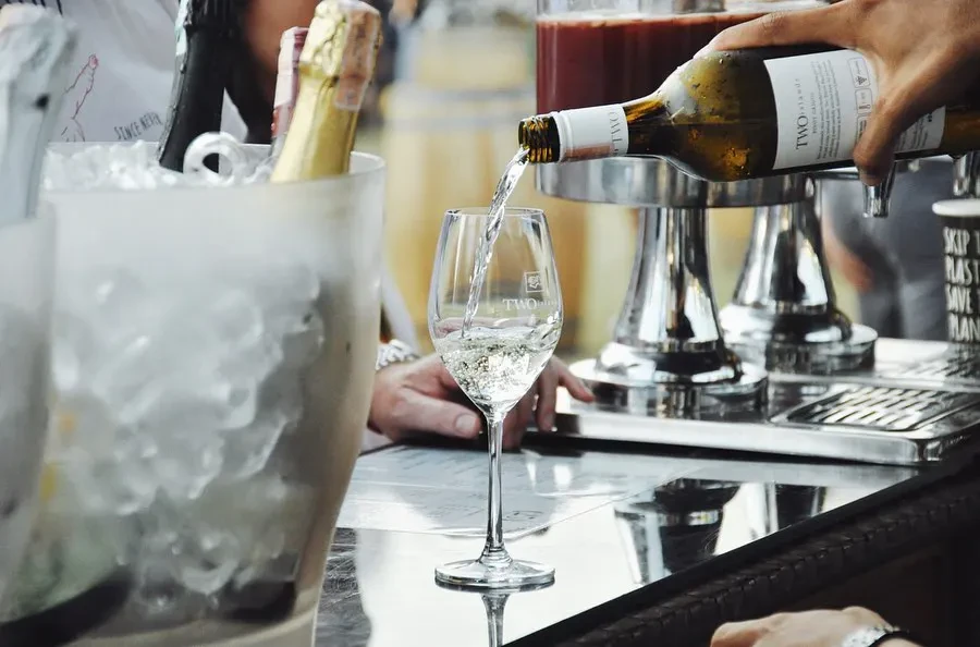 Guests enjoying a communal wine-tasting lunch at Hatten Wines Cellar Door in Bali, featuring rustic brick interiors and premium Bali-grown wine pairings.